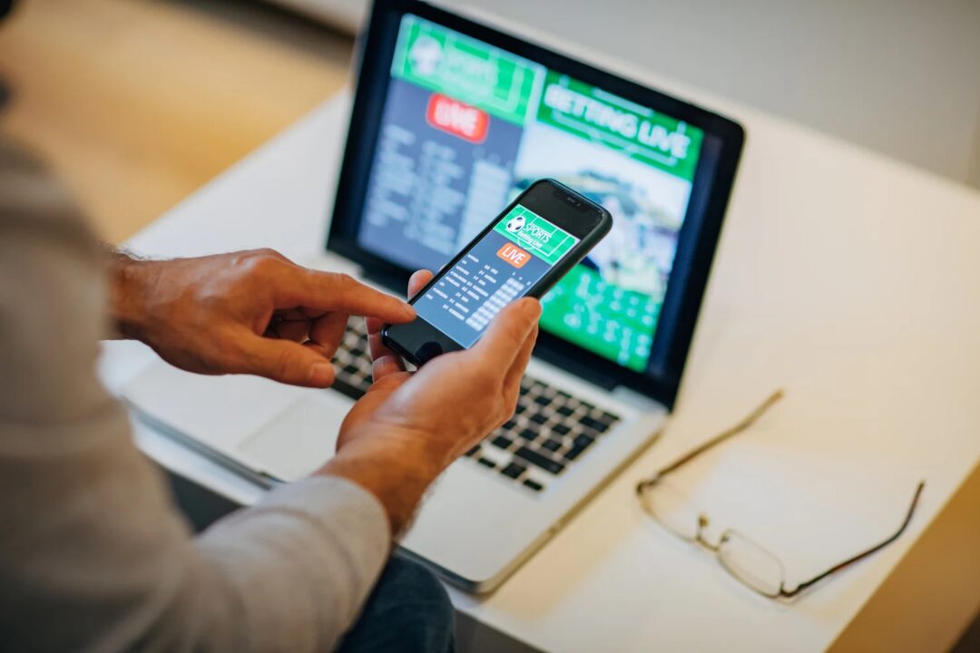 Pessoa apostando pelo celular com aplicativo de apostas esportivas ao vivo